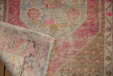 Distressed Oushak rug's pile with visible foundation, showing hand-knotted reverse.