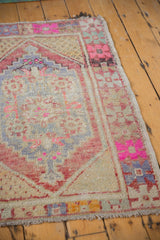 Geometric corner detail of distressed Oushak rug, blush, red, and pale gold colors.