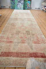 Distressed Oushak runner texture, showing geometric patterns in faded ivory and chestnut red.