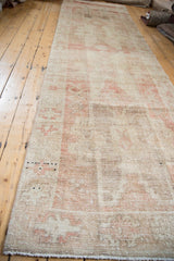 Distressed Oushak runner pile with even wear, faded ivory, and coffee brown geometric design.