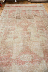 Distressed Oushak rug pile texture showing even wear, faint foundation, faded reds, and ivory geometric motifs.
