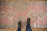 Distressed vintage Turkish Sparta runner with rose blush, ivory geometric pattern, showing wear.