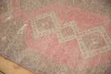 Distressed texture of bubble gum rose blush and beige medallions on a vintage Sparta rug.