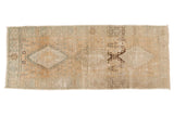 Distressed vintage Oushak runner features faded triple diamond medallions on an abrash ivory-beige field.