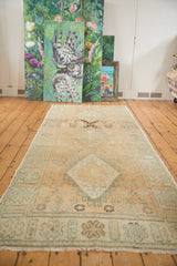 Distressed Oushak runner showing pale beige diamond medallion, ocean green accents and abrashes.