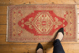 Fringe and red running-t border on vintage distressed Oushak rug corner.
