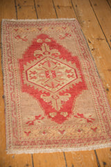 Oversized finial with cherry red and beige motifs on vintage distressed Oushak rug.