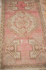 Distressed pile texture with serrated geometric patterns in blush pink and ivory on Oushak rug.