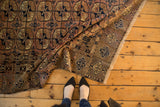 Vintage Turkmen carpet folded, chestnut field with navy Bokhara guls, unique border.