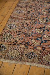 Vintage Turkmen carpet end, chestnut and navy Bokhara guls, low pile, ivory fringe.