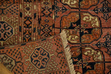 Corner of vintage Turkmen rug showcasing unique pomegranate motif border and ivory fringe.