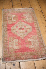 Distressed Oushak rug's secured side cord selvage and blush fringe detail.
