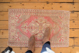 Blush, silver, ivory distressed Oushak rug mat, geometric medallion, shown with boots.