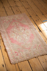Distressed Oushak rug corner with blush pinwheel and rams horn floral motif.
