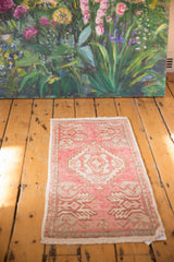 Distressed Oushak rug mat end, pale pink and ivory pattern, even wear and fringe.