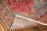 Distressed Oushak rug corner revealing reverse foundation, fringe, and original side selvage.