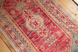 Distressed Oushak rug runner with cherry red and aqua blue rams horn motifs and low pile.