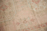 Distressed Oushak rug detail: faded blush and ivory floral motifs with even wear.