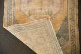 Distressed ochre and dusty blue Oushak rug pile with its hand-knotted, natural reverse foundation.
