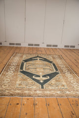 Navy hexagonal medallion with rams horn motifs on a distressed Northwest Persian rug.