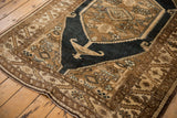 Distressed Northwest Persian rug corner, featuring serrated leaf border in light bronze and navy.
