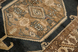 Light bronze hexagonal medallion and rams horn lanterns on a distressed navy blue Northwest Persian rug.