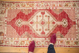 Distressed vintage Oushak runner with cherry red and ivory geometric medallion.