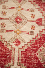Distressed hand-knotted pile showcasing cherry red and ivory stepped geometric patterns.