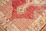 Distressed cherry red field of a vintage Oushak rug with serrated motif and ivory corner overlay.