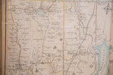 Angled view of antique Somers, New York map, showing cream paper, black text, blue water.