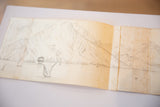 Angled view of the antique unfinished sketch of Hotel Biron's seascape, showing aged paper and folds.