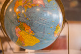Vintage 1960s Cram's Scholastic globe displaying the blue Atlantic, Central, and South America.