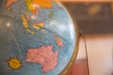 Vintage 1960s Cram's blue globe showing pink Australia, yellow Asia, and brass axis.