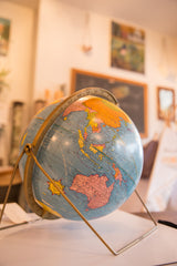 Vintage blue Cram's scholastic globe, showing Australia and the brass axis base.