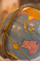 Vintage Cram's globe showing pink Australia, yellow Asia, and brass meridian.