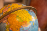 Vintage globe map of Soviet Socialist Republics, blue oceans, and brass axis.