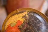 Black Mid Century globe with Asia's yellow landmasses, red China, and era-specific labels.