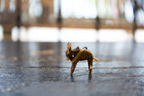 Hand-painted dark wooden bull ornament showing worn texture and golden yellow accents.