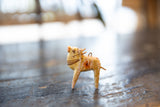 Side profile of vintage wooden cow ornament, highlighting worn hand-painted details and tail.