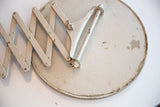 Accordion arm and chipped white paint with patina on antique shaving mirror back.