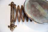 Aged metal accordion arm and distressed mirror glass of the antique shaving mirror.