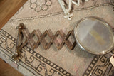 Close-up of the antique shaving mirror's circular, aged glass surface with significant patina.