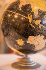 Cram's Universal label and patinated metallic base on a vintage black globe.