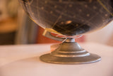 Mid Century Cram's black globe: unusual silver-toned metal base with concentric rings.