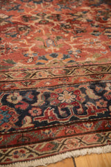 Intricate navy blue border patterns meeting the cherry red field of a vintage Mahal carpet.