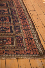 Close-up of Antique Belouch rug border: germinating plant motif, madder root, navy, and light tatter.