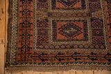 Antique Belouch rug corner: madder root and navy germinating plant motif border, fringed edge.