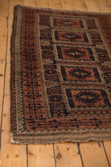 Antique Belouch rug corner with madder root germinating plant border and light tatter.