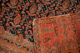 Antique Malayer rug with red foundation, intricate geometric reverse, tattered fringe, and dark boteh pile.