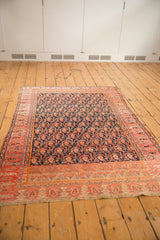 Antique Malayer rug corner, fuschia raspberry border motifs, navy blue boteh field, light tatter.